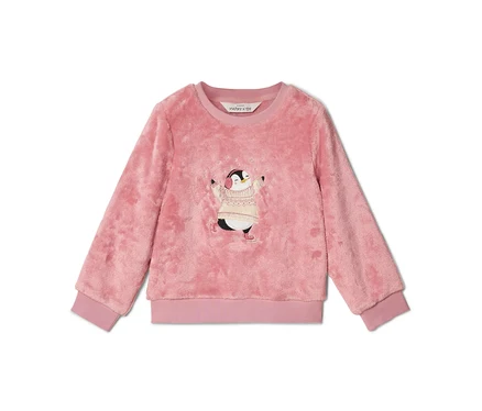Pull en peluche rose à col rond et bords-côtes. Il présente un motif brodé d'un pingouin portant un pull tricoté crème et des cache-oreilles roses, entouré de flocons de neige blancs.