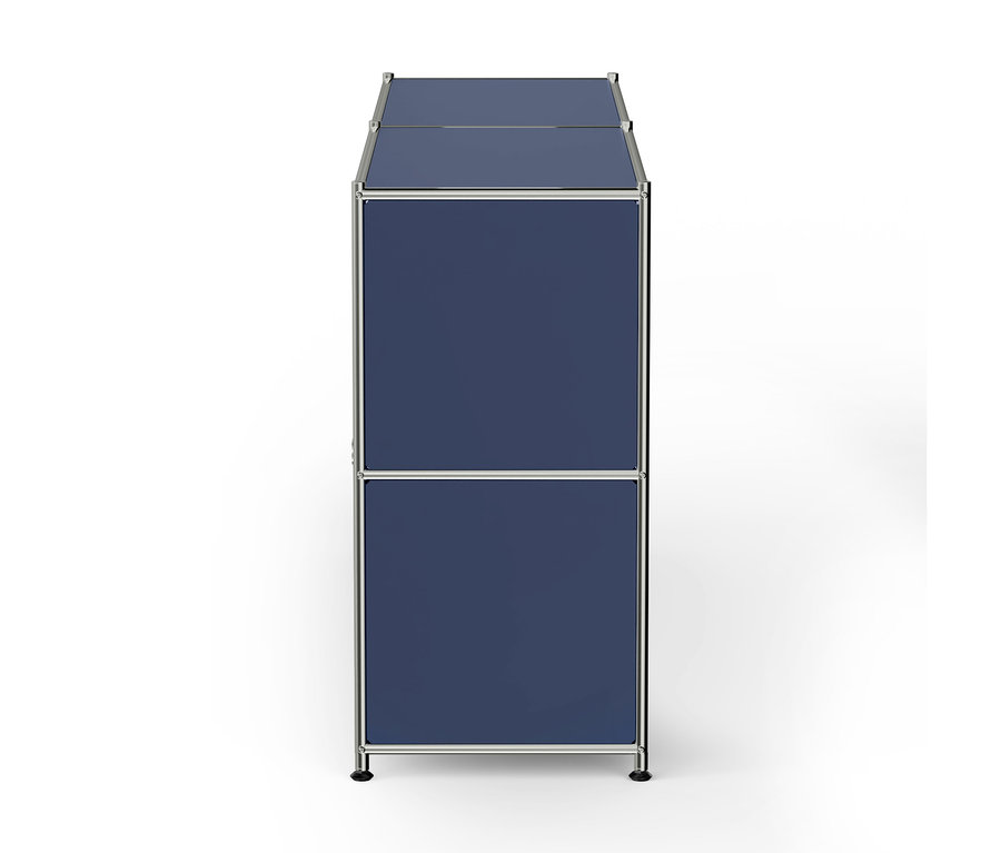 Meuble de rangement modulaire bleu, haut et étroit, avec deux compartiments et un cadre chromé, reposant sur des pieds noirs.
