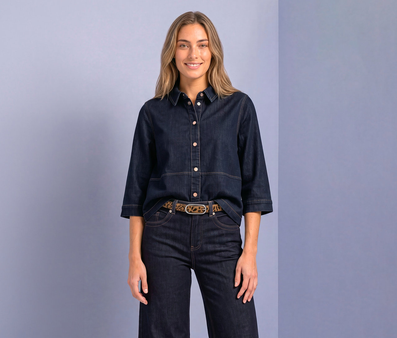 Femme souriante portant un chemisier Street One en jean foncé avec des manches 3/4, un pantalon en jean foncé et une ceinture imprimé léopard.