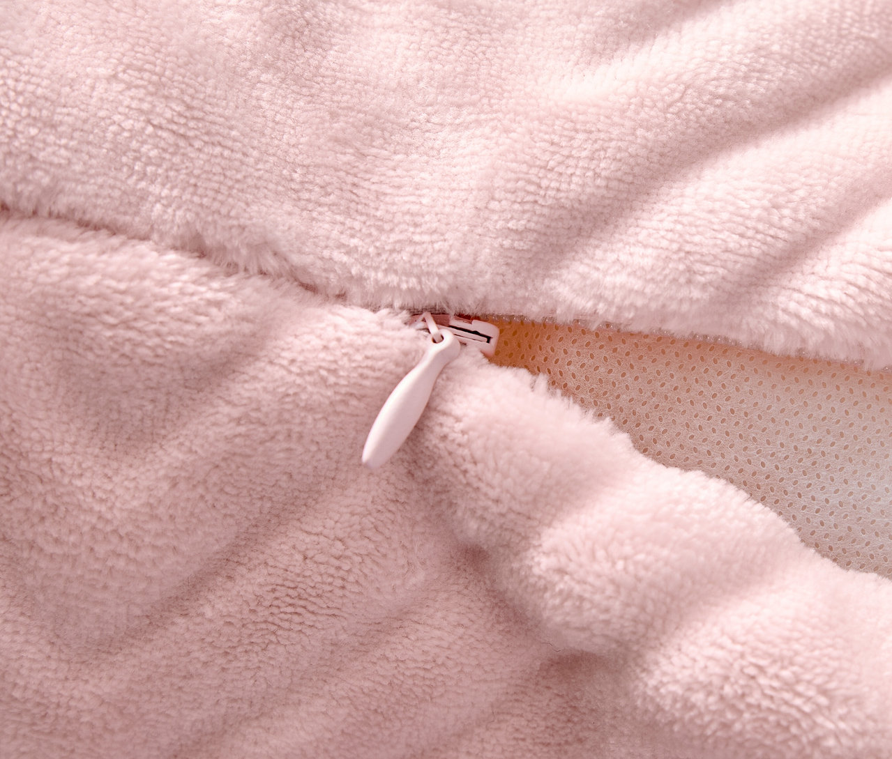 Gros plan d'une taie d'oreiller rose avec une fermeture éclair.