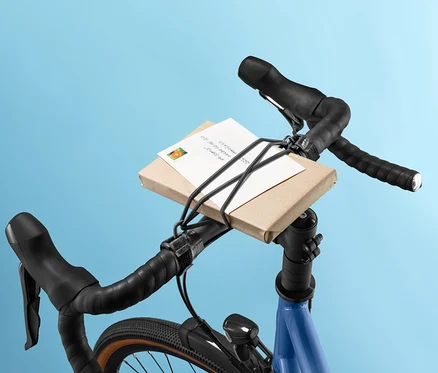 Paquet sur le guidon du vélo fixé par une sangle de fixation sur le guidon.