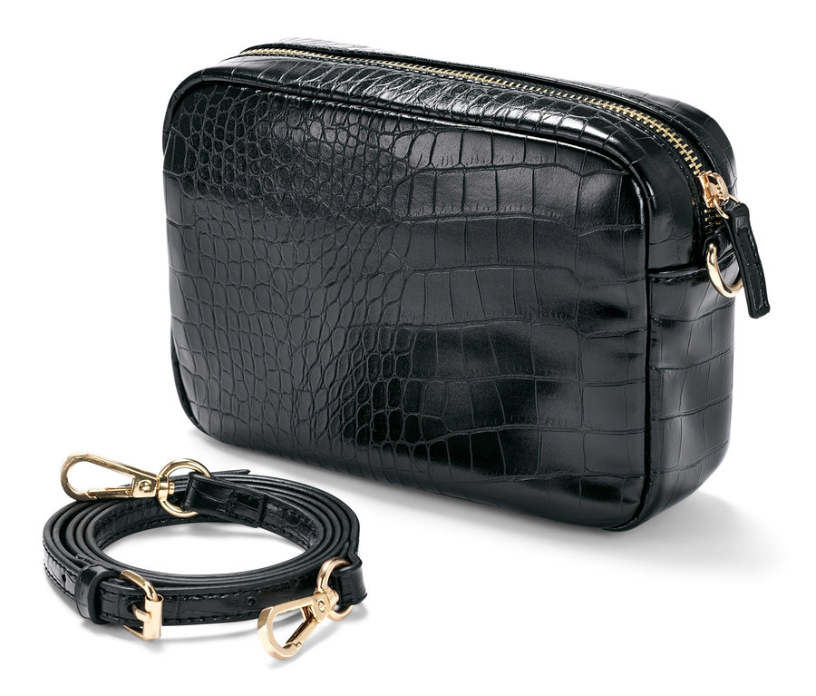 Un sac à bandoulière noir à texture croco repose à côté d'une bandoulière amovible.