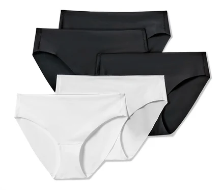 Quatre slips Magic Cut, 5 pièces, deux noirs et deux blancs, sont posés les uns sur les autres.