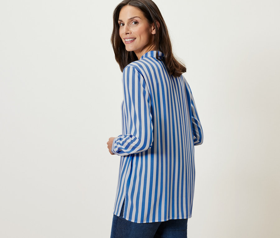 Femme regardant par-dessus son épaule portant une Chemisier rayé.