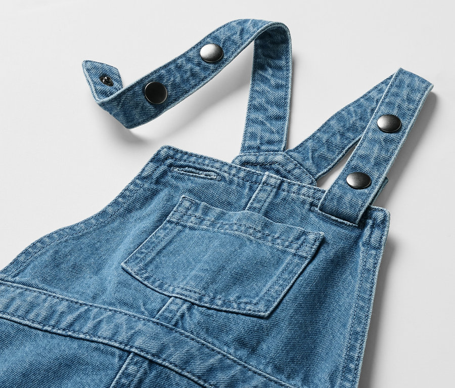 Robe-salopette pour enfant avec poche poitrine et bretelles réglables avec boutons.