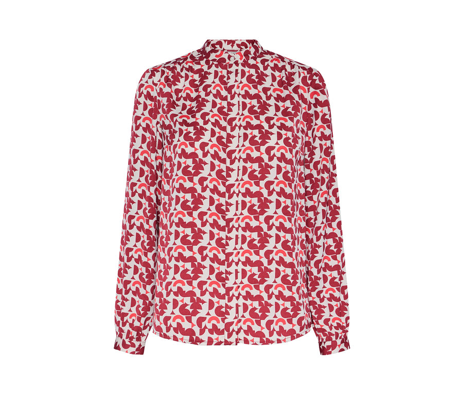 Détail d'un chemisier imprimé avec un motif géométrique rouge.