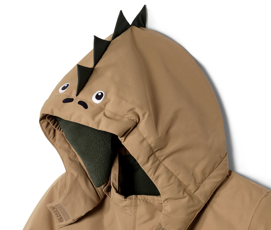 Gros plan sur un vêtement de neige pour enfant avec une capuche à motif de dinosaure.
