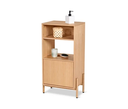 Une armoire de salle de bain avec placage bois a deux étagères ouvertes, l'étagère du haut contient une pompe blanche et un panier, l'étagère du bas contient une tasse et une brosse.