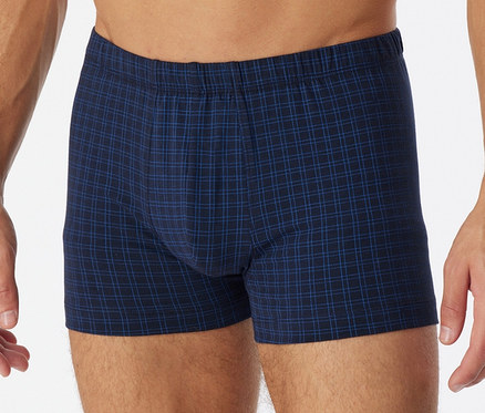 Un homme porte un short SCHIESSER à carreaux.