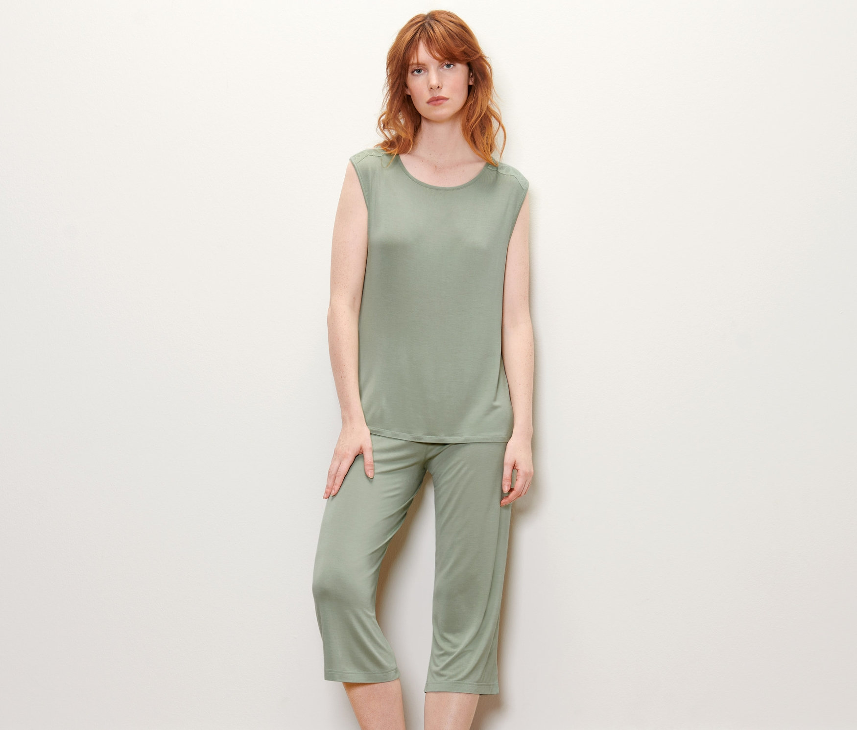 Femme posant en pyjama vert.