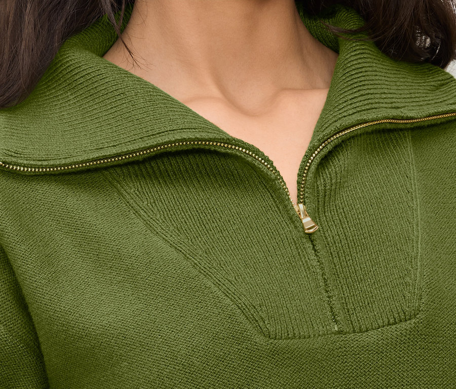 Gros plan sur un pull en maille vert olive à col zippé pour femme.