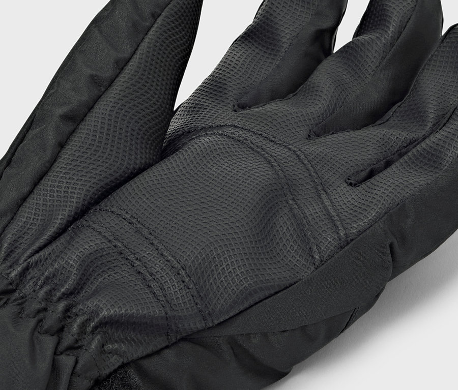Gros plan d'un gant noir avec une paume texturée.