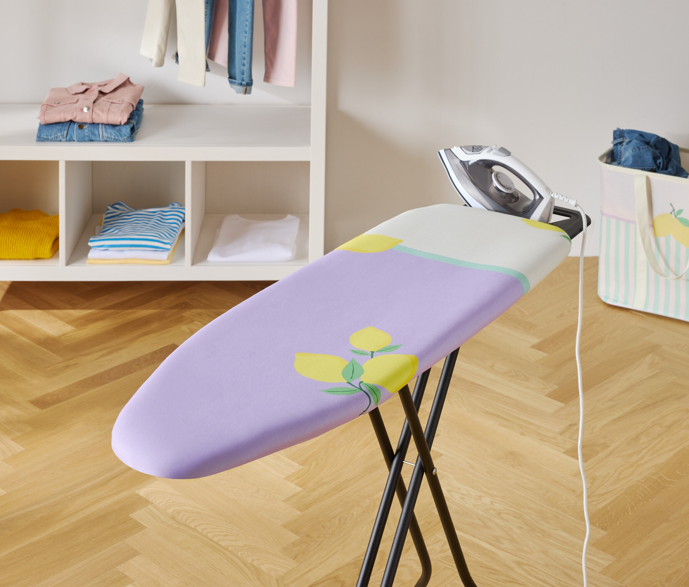 Fer à repasser sur une planche à repasser avec une housse violette et un motif floral.