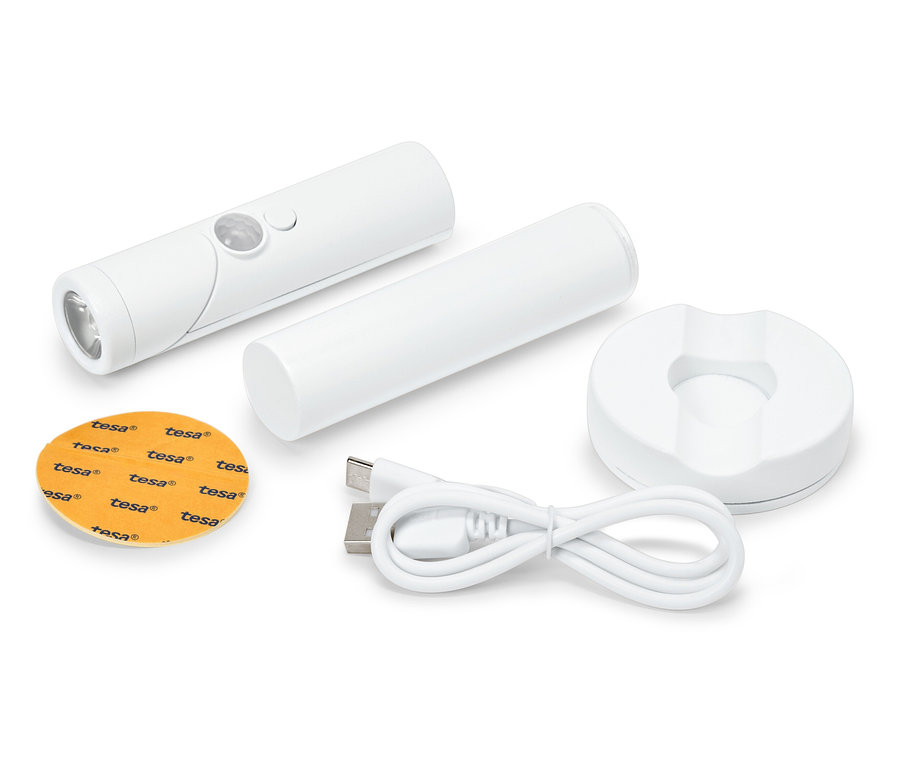 Un ensemble composé d'une lampe LED blanche, d'un câble de chargement, d'une base ronde et d'un tampon adhésif.