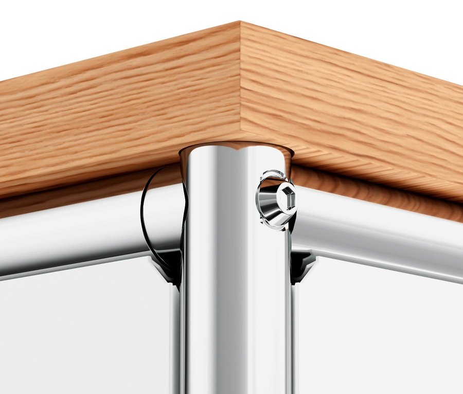 Détail d'un coin du meuble en métal « CN3 » avec plateau en bois et portes blanches.