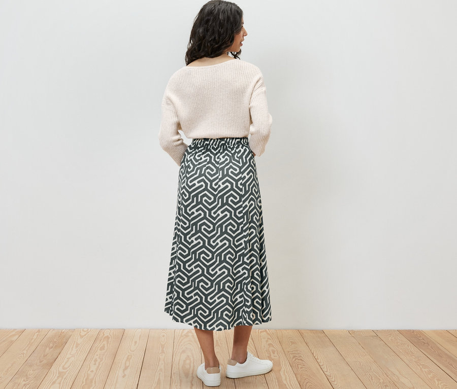 Femme vue de dos portant une jupe midi imprimée.