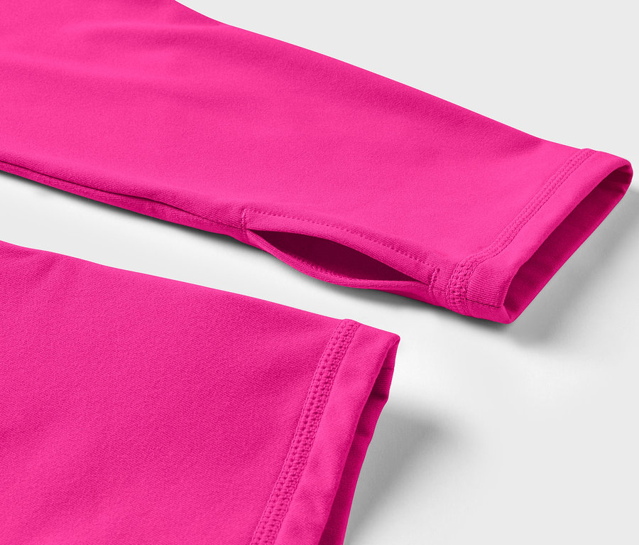 Gros plan sur un t-shirt à manches longues rose avec un trou pour le pouce.
