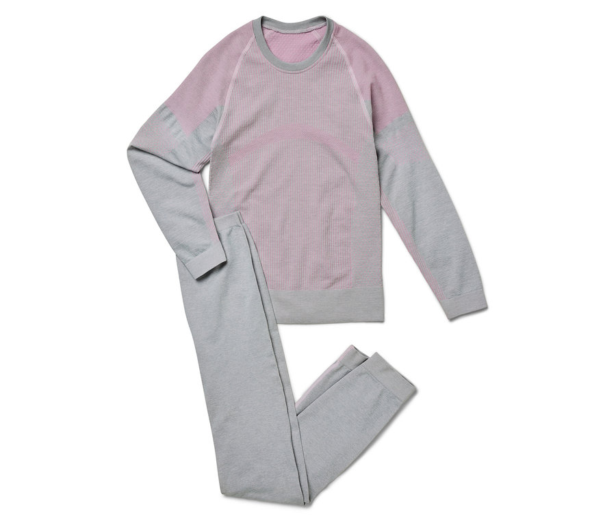 Un pantalon de survêtement gris et un t-shirt à manches longues avec des détails roses sont posés sur un fond blanc.