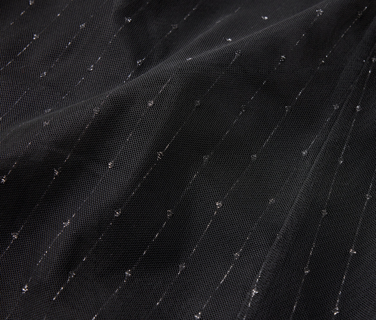 Gros plan d'un tissu noir avec des rayures et des points argentés diagonaux.
