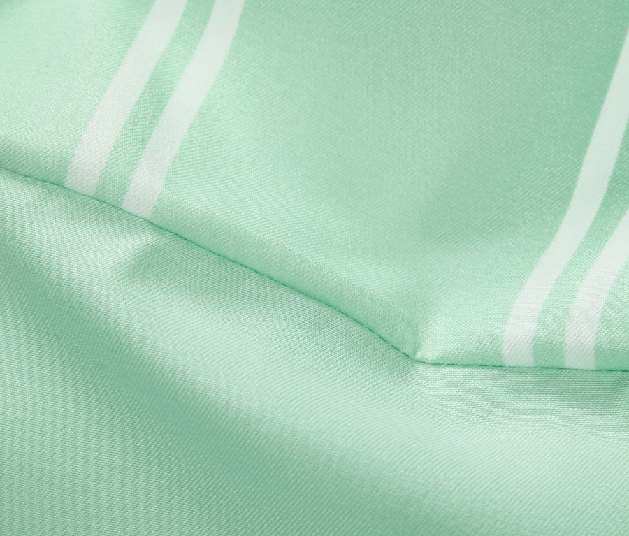 Gros plan d'un tissu vert clair avec des rayures blanches.