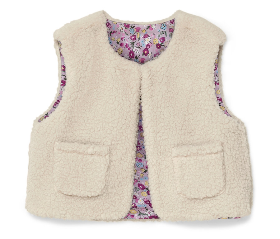 Un gilet sans manches crème et duveteux avec deux poches plaquées et une doublure à fleurs.