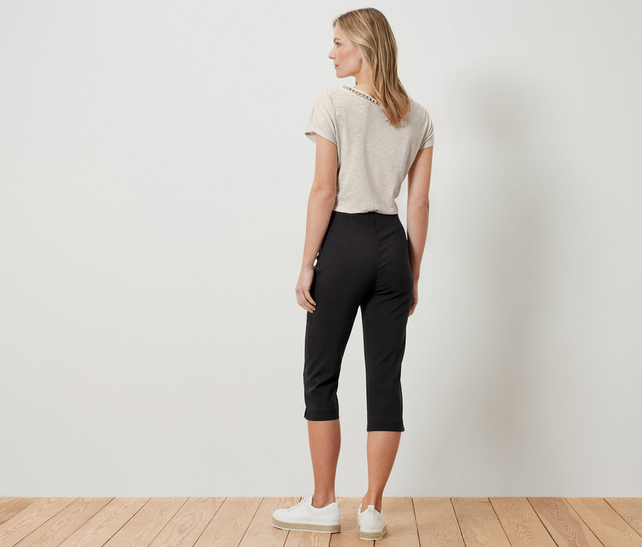 Femme vue de dos portant un pantalon 3/4 stretch, noir.