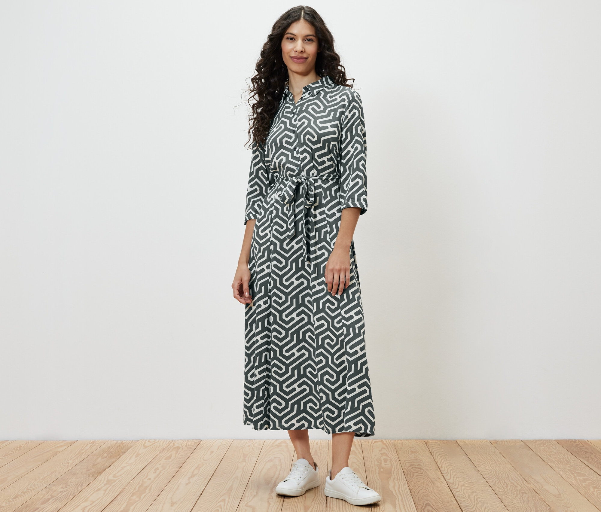 Une femme debout portant une robe chemise imprimée.