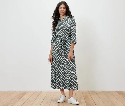 Une femme debout portant une robe chemise imprimée.