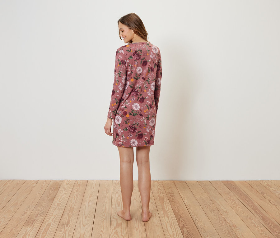 Une femme, vue de dos, porte une robe à fleurs.