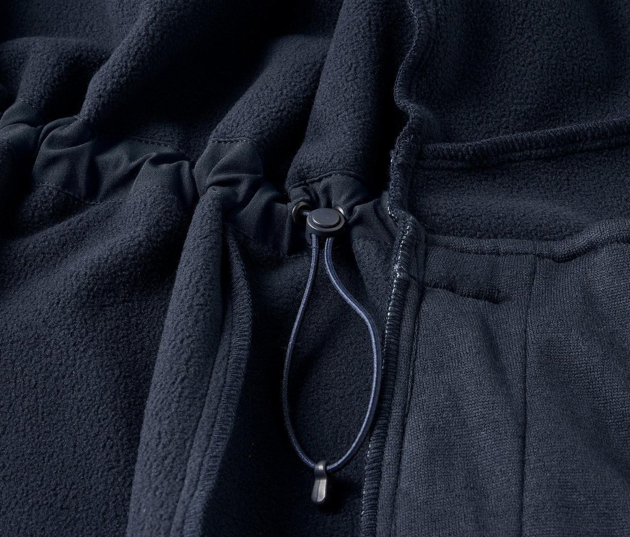 Détail d'un manteau en softshell bleu marine.