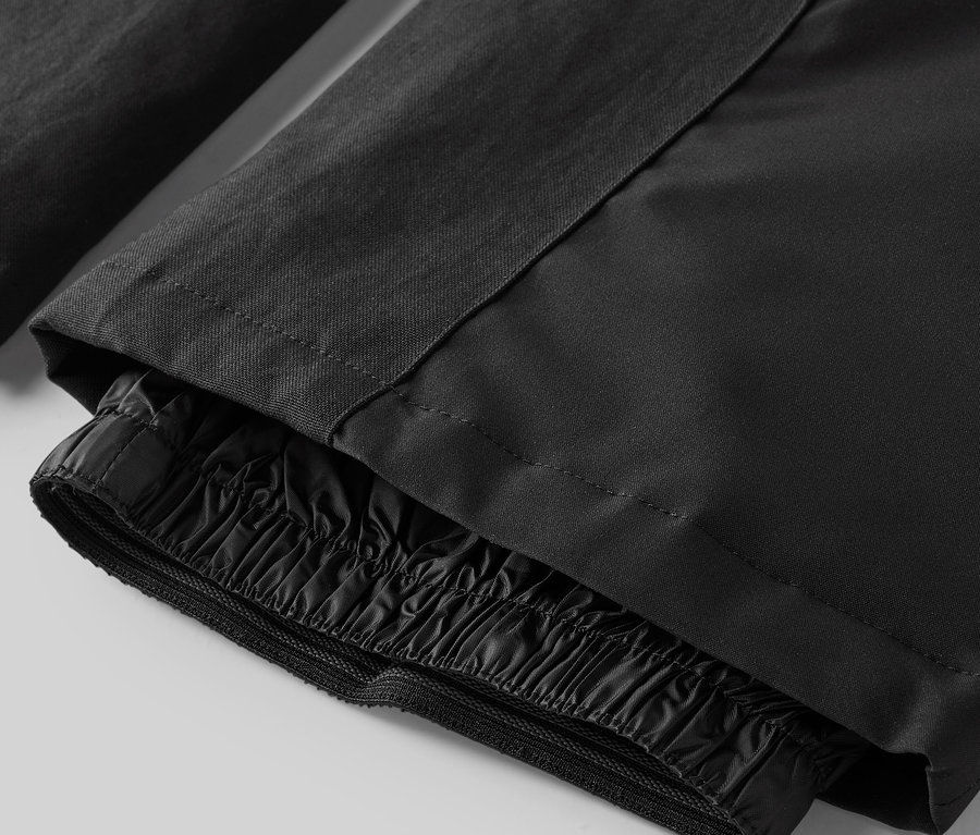 Gros plan sur un pantalon noir avec élastique aux chevilles.