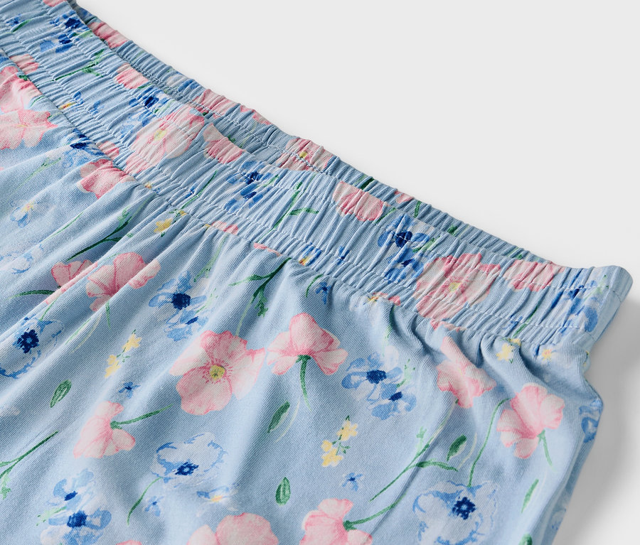 Détail d'un pantalon bleu clair à motif floral avec une taille élastique.
