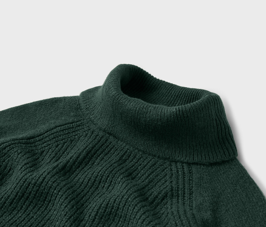 Gros plan d'un pull à col roulé vert foncé avec une texture côtelée.