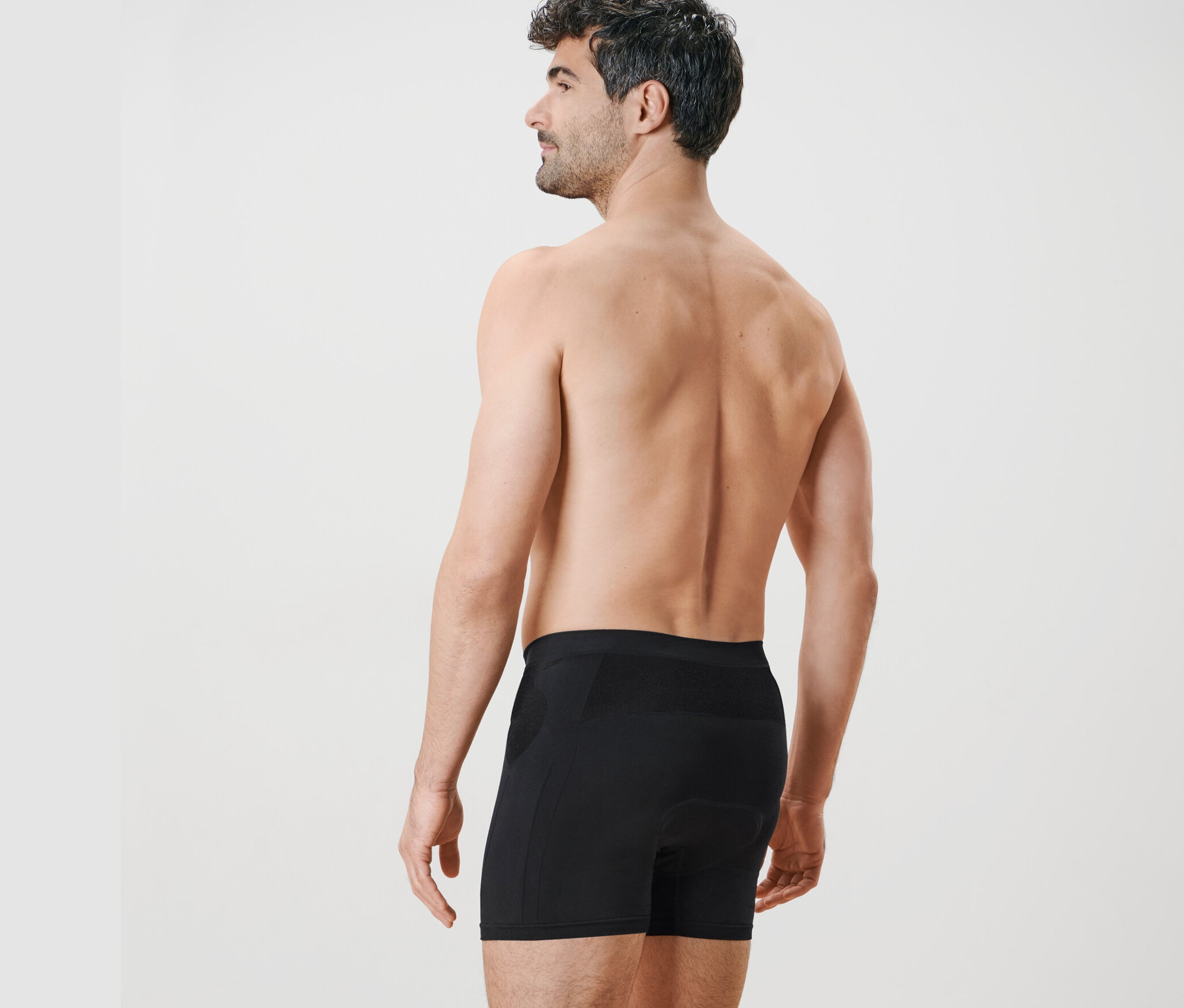 Un homme vu de dos porte un boxer de vélo noir.