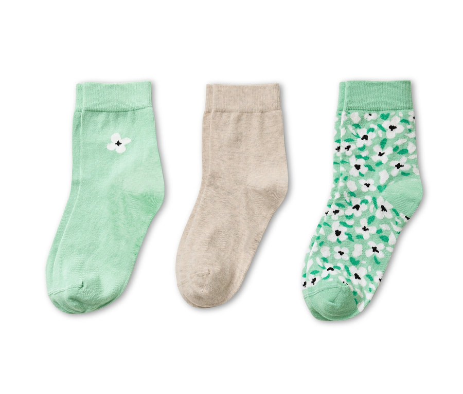 Trois paires de chaussettes : une paire vert clair avec une fleur blanche, une paire beige et une paire vert clair avec un motif floral.