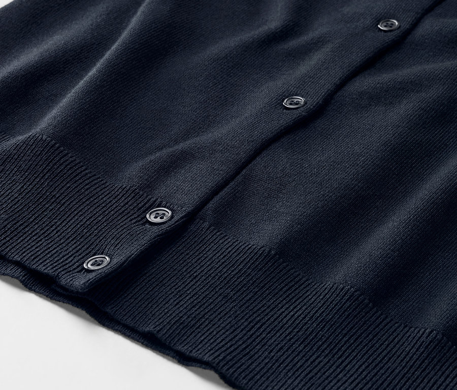 Gros plan sur un cardigan bleu en maille fine avec des boutons.