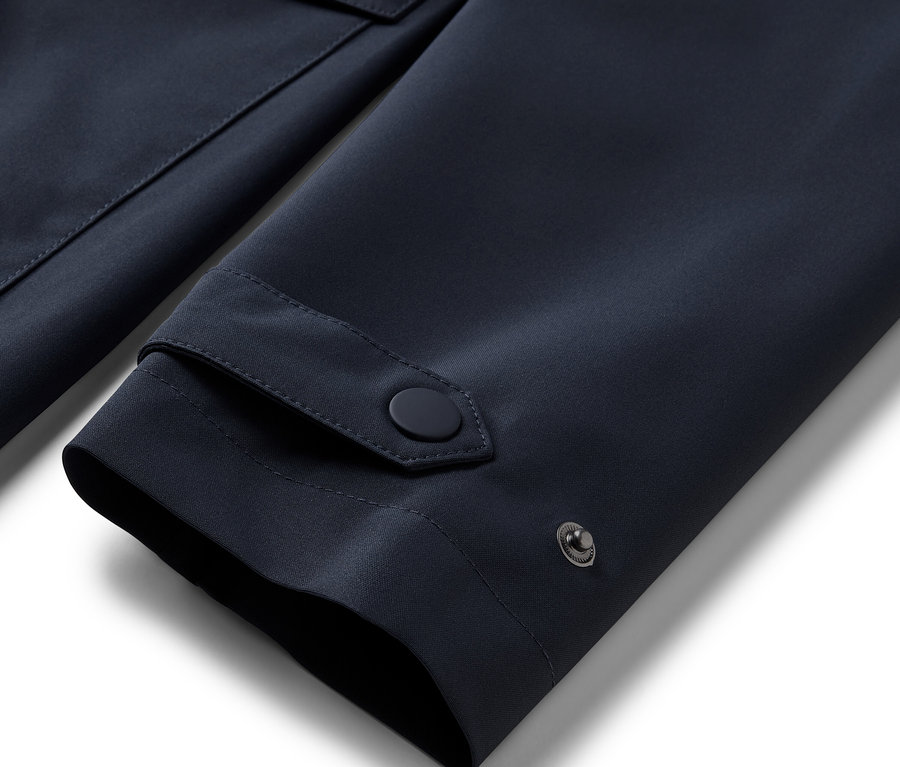 Détail de la manche d'un trench-coat de pluie bleu.