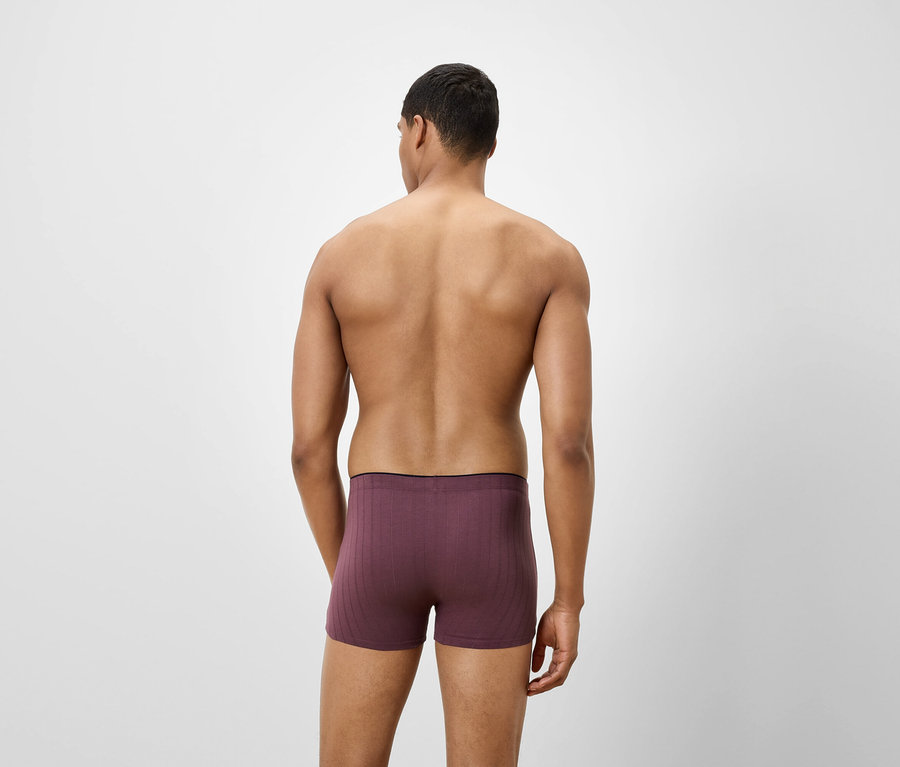 Homme vu de dos portant un boxer violet.