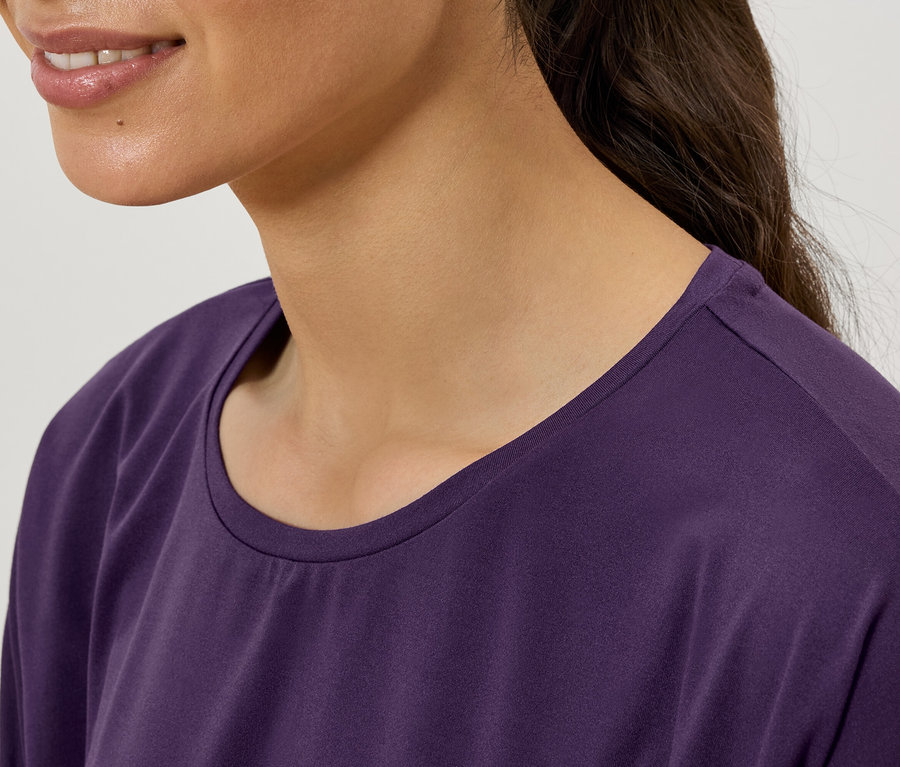Gros plan d'une femme portant un t-shirt violet à col rond.