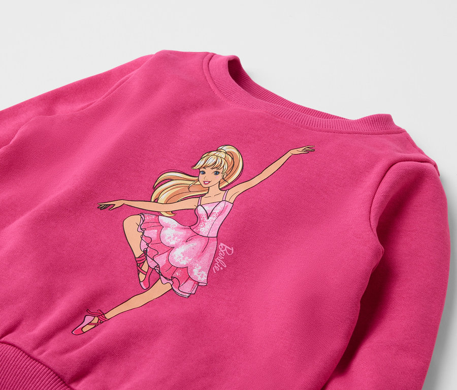 Sweat-shirt rose avec une image d'une poupée Barbie dansant.
