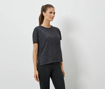 Femme portant un t-shirt de sport noir à manches courtes et un legging noir.