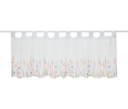 Un court store blanc à motifs floraux est suspendu à une tringle.