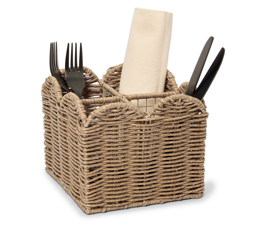 Un panier en osier avec des compartiments pour les couverts et les serviettes, rempli de fourchettes et de couteaux noirs et d'une serviette roulée.