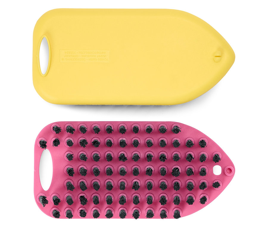 Un support de brosse jaune est posé sur un support de brosse rose avec des poils noirs.