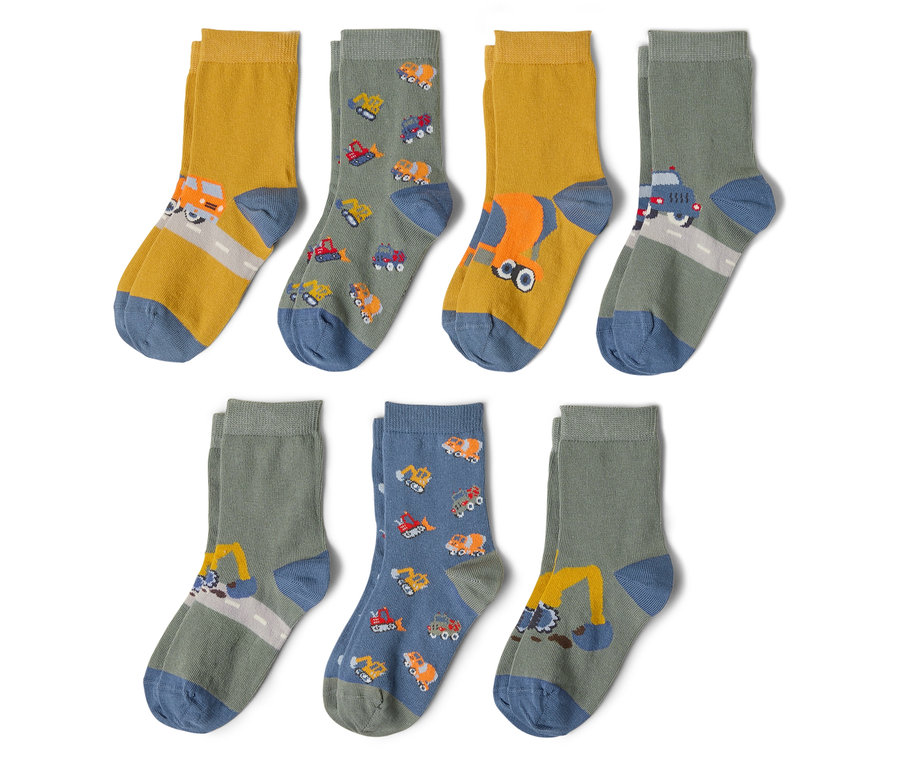 Six paires de chaussettes sont posées sur un fond blanc. Les chaussettes sont imprimées avec différents véhicules de construction tels que des excavatrices, des camions et des bétonnières.