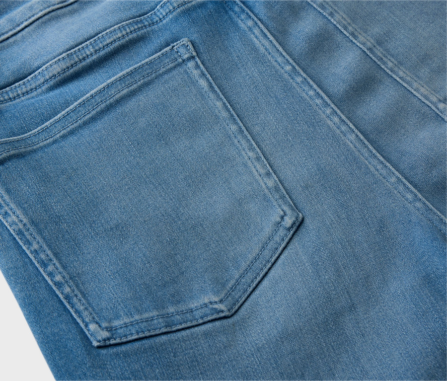 Gros plan de l'arrière d'un jean bleu clair avec une poche arrière.