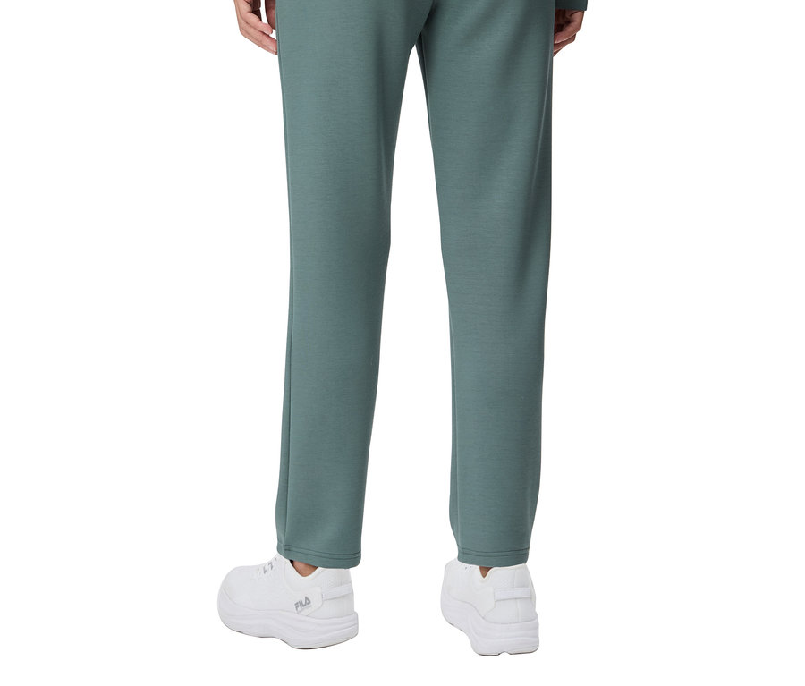 Vue arrière d'une personne portant un pantalon plazzo pour femmes FILA en mélange modal et des baskets blanches.