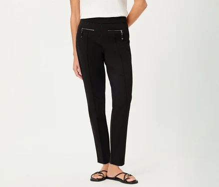 Une femme porte un pantalon Olsen, slim, noir avec des poches zippées et des sandales noires sur fond blanc.