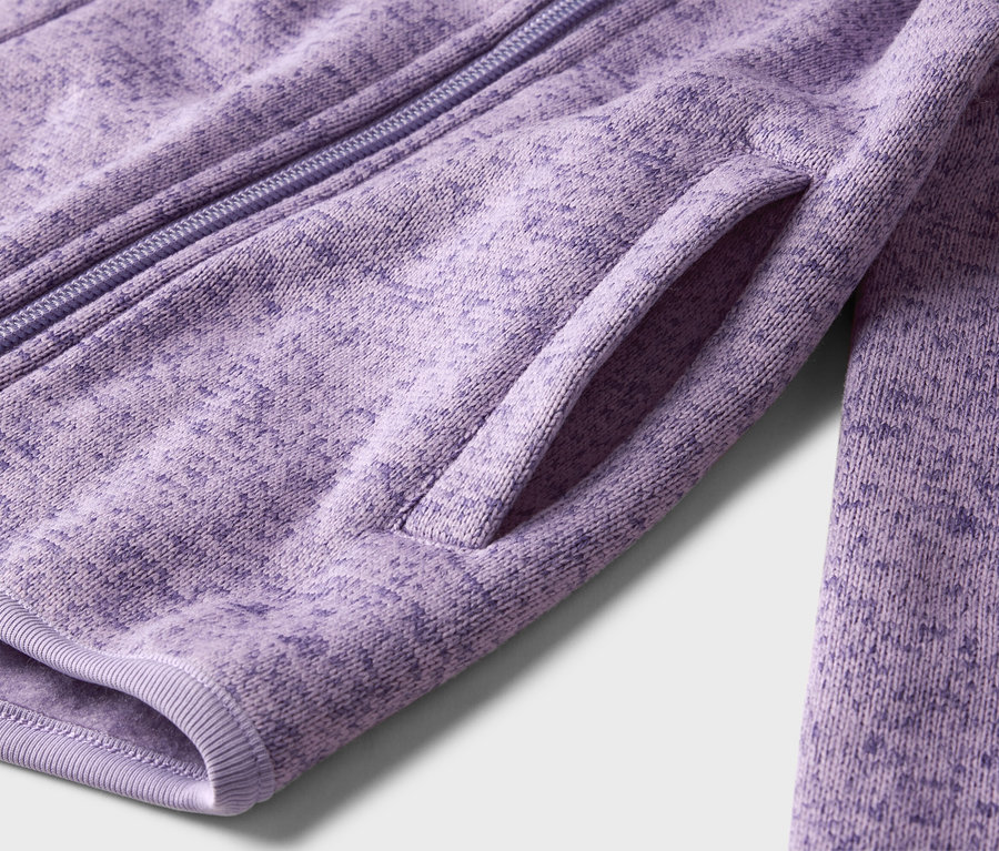 Gros plan sur une veste en polaire violette avec fermeture éclair et poche.