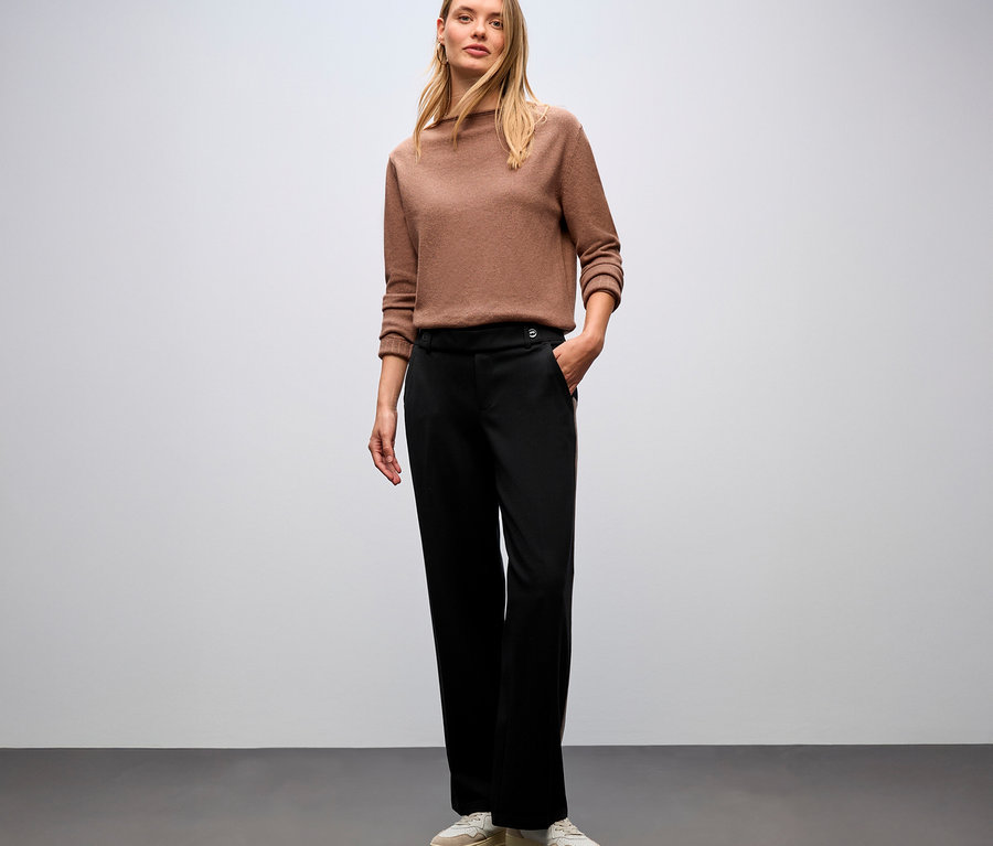 Femme debout portant un pull marron et un pantalon straight leg avec galon noir de Street One.